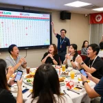 Excited participants checking their HK Lotto tickets during a live lottery draw event in a festive atmosphere.