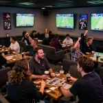 Sunwin sports fans passionately cheering and placing bets in a lively sports betting lounge.